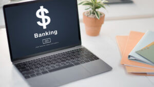 A laptop with banking sign on the screen depicting bank account is opened.