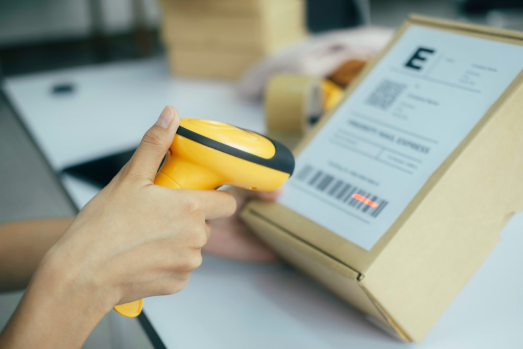 a person is scanning code of the delivery box that needs to be shipped.