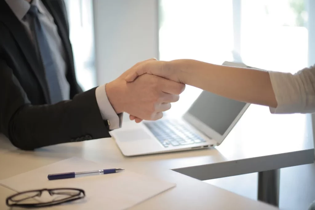 A business consultant in a suit shaking hand with the client